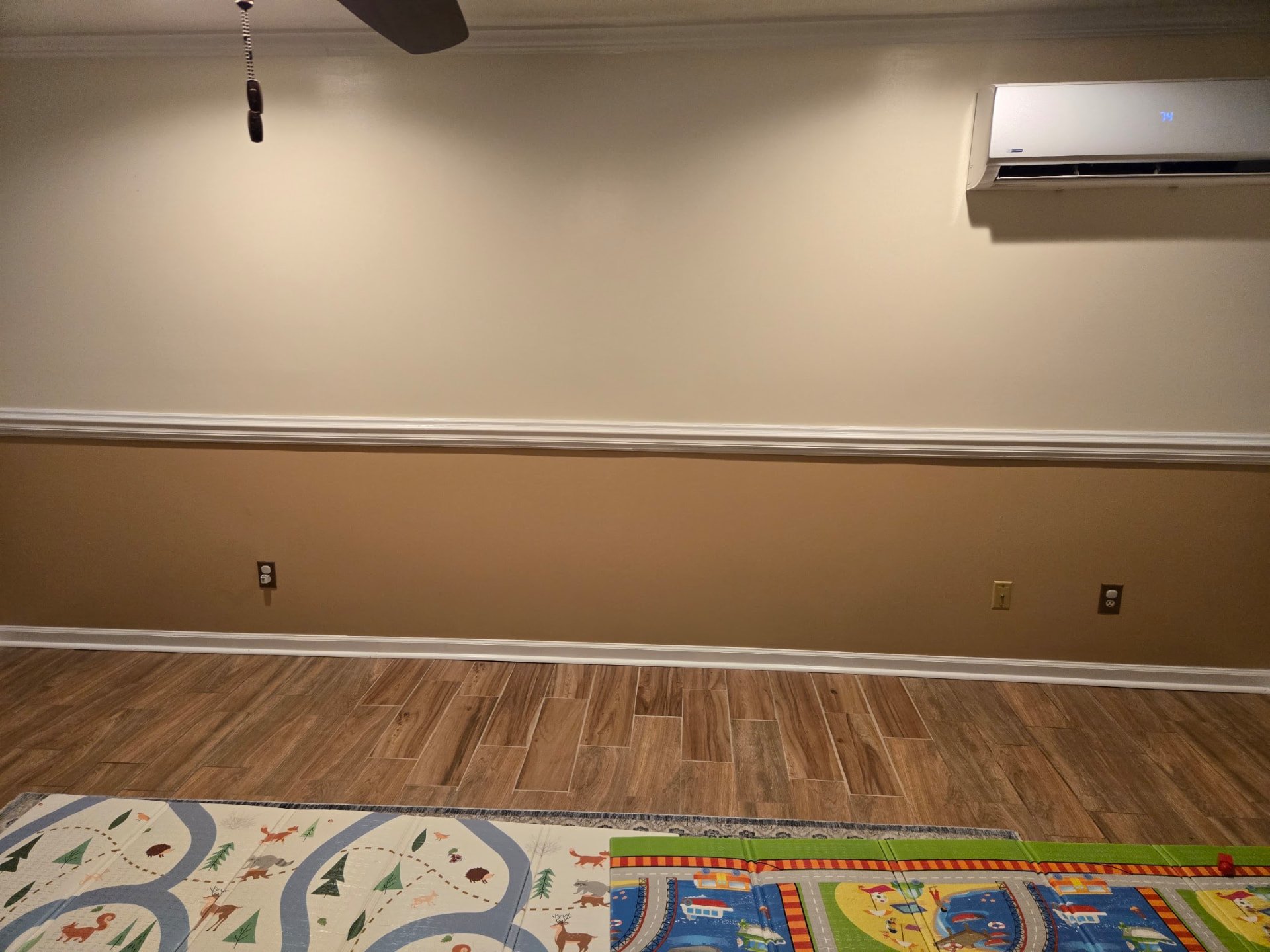Installed flooring and baseboards in a room with play mats